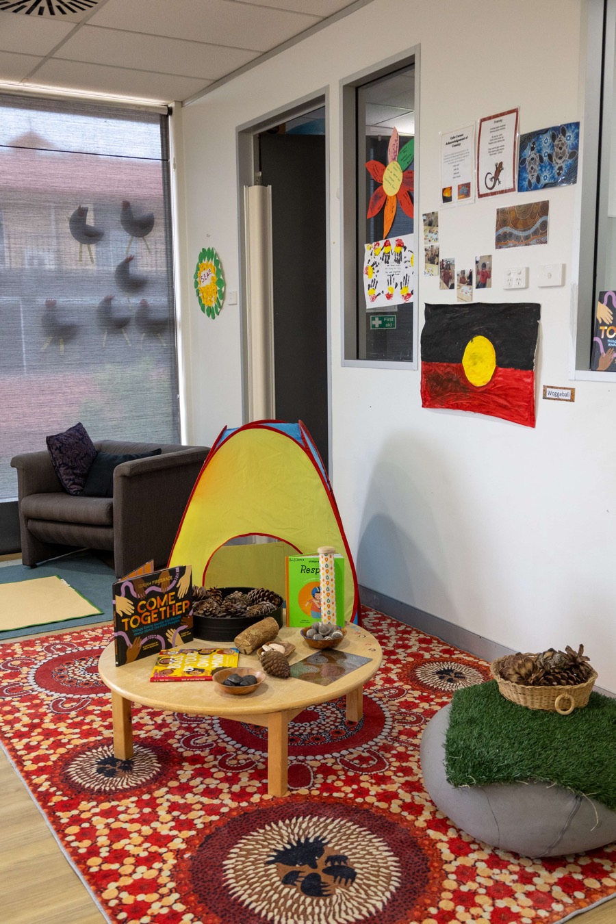 A cultural corner at Cubs Corner with an Aboriginal flag, a rug, cushions and a small tent