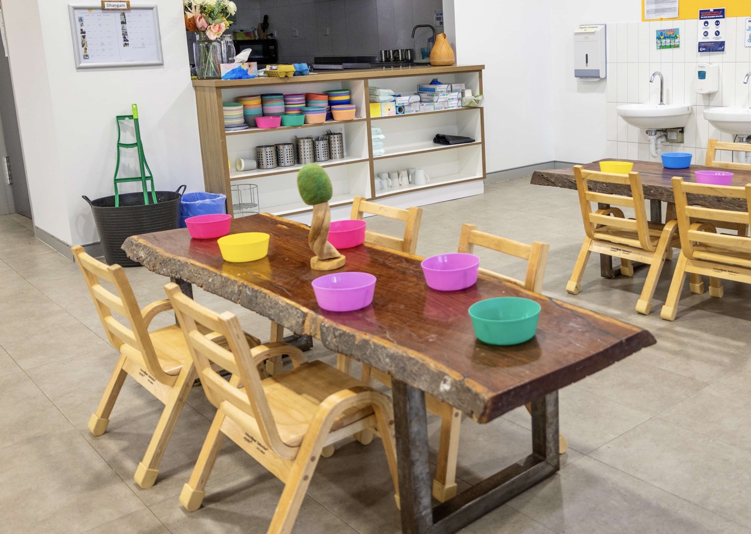 Timber dining tables set with bowls in front of the Cubs Corner kitchen